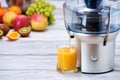 Modern electric juicer, various fruit and glass of freshly made juice, healthy lifestyle, detox concept Royalty Free Stock Photo