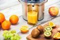 Modern electric juicer, various fruit and glass of freshly made juice, healthy lifestyle detox concept Royalty Free Stock Photo