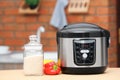 Modern electric multi cooker, jar of rice and peppers