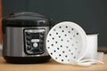 Modern electric multi cooker, parts and accessories on table Royalty Free Stock Photo