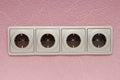 Modern electric socket  in interior, grey wall outlet on pink wall Royalty Free Stock Photo