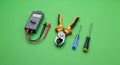 Modern Electrical & Hand Tools: Multimeter, Pliers, Screwdrivers on Vivid Green Background Royalty Free Stock Photo