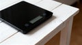 Modern electronic kitchen scale on white wooden table closeup Royalty Free Stock Photo