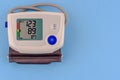 Modern electronic medical pressure monitor on a blue background