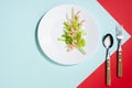 Modern elegant geometric style in food - appetizer of shrimps, greens, celery, teriyaki sauce in white plate with cutlery.