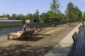 A modern embankment equipped with sun loungers in the city on the banks of the Guslitsa River. Urbanism