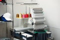 Modern embroidery machine with spools of thread indoors Royalty Free Stock Photo