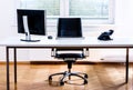 Modern empty office space desk with computer, phone and chair. Royalty Free Stock Photo