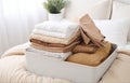 modern empty openned suitcase on white bed on white bedroom background