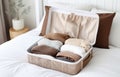 modern empty openned suitcase on white bed on white bedroom background