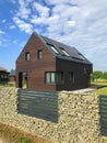 Modern energy efficient house with solar panels and gabion fence Royalty Free Stock Photo