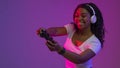 Modern Entertainment. Smiling Black Woman In Neon Light With Joystick In Hands