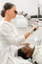 Modern equipment microscope in dental office. Young woman dentist treating root canals. Man patient lying on dentist Royalty Free Stock Photo
