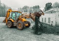 The modern excavator performs excavation work on the construction site. Front view of a digger bucket of digging ground as a part Royalty Free Stock Photo