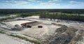 Excavator pours ore into red tipper at sand pit upper view