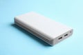 Modern external portable charger on blue background, closeup