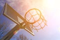 Modern extra strong metal basketball ring on the background of the blue sky and sun