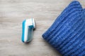 Modern fabric shaver for lint removing and sweater on wooden table, flat lay Royalty Free Stock Photo