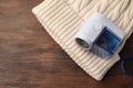 Modern fabric shaver and white knitted hat on wooden table, top view. Space for text Royalty Free Stock Photo