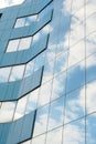 modern facade of glass and steel with reflections. Abstract or graphic photo of the sky with clouds seeming to continue Royalty Free Stock Photo