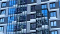 Modern facade of a new residential complex, blue glass facade glazing. Residential apartments or architecture of an