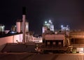 Modern factory industrial plant at night, stainless steel cooling tower and pipelines, copy space Royalty Free Stock Photo