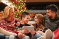Modern family having fun on digital tablet for Christmas Royalty Free Stock Photo
