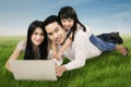 Modern family with laptop on grass Royalty Free Stock Photo