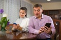 Modern family sitting with smartphones in home interior Royalty Free Stock Photo