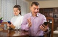 Modern family sitting with smartphones in home interior Royalty Free Stock Photo