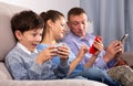 Modern family sitting with smartphones in home interior Royalty Free Stock Photo