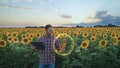 Modern farmer checking quality of sunflower oil at a Helianthus field
