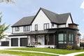 A modern farmhouse with black and white siding.