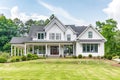 Modern farmhouse with gabled roof constructed by board and batten. Generative AI.