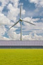 Modern farmhouse with solar panel roof in front of a large wind turbine in The Netherlands Royalty Free Stock Photo