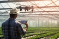 Modern farming: drone assists greenhouse farmer, monitoring crops and irrigation.