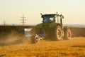 Modern farming with tractor in plowed field