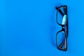 Modern fashionable and office spectacles on blue background, Perfect reflection, eye glasses on table for copy space Royalty Free Stock Photo