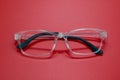 Modern fashionable spectacles on red background. Royalty Free Stock Photo