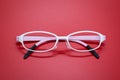 Modern fashionable spectacles on red background. Royalty Free Stock Photo