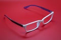 Modern fashionable spectacles on red background. Royalty Free Stock Photo