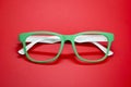 Modern fashionable spectacles on red background. Royalty Free Stock Photo