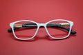 Modern fashionable spectacles on red background. Royalty Free Stock Photo