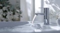 Modern faucet with flowing water over a pristine sink Royalty Free Stock Photo
