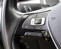 A modern feature in the car is the adaptive cruise control button on the steering wheel. Change of speed, close-up