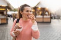 Modern female at fair in city eating trdelnik