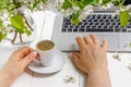 Modern feminine workplace concept. Laptop, coffee, beautiful apple tree flowers  on the white table, top view Royalty Free Stock Photo