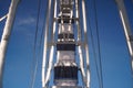 modern ferris wheel with closed cabins at carnival with blue sky no clouds in the background illuminated wide angle close up shot Royalty Free Stock Photo