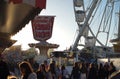 modern ferris wheel with closed cabins at carnival with blue sky no clouds in the background illuminated wide angle close up shot