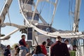 modern ferris wheel with closed cabins at carnival with blue sky no clouds in the background illuminated wide angle close up shot